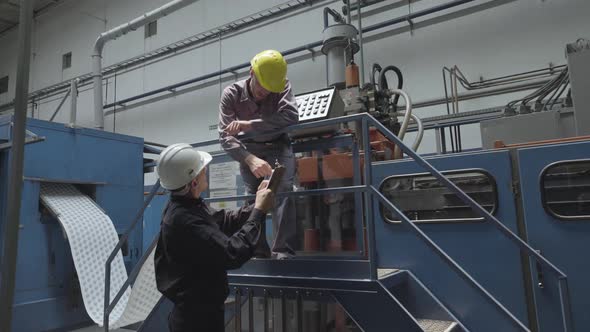 Factory workers discussing with each other in factory