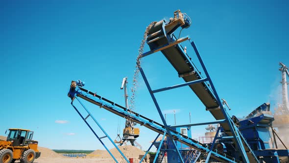 Mining Industry Concept. Crushed Stones Falling From a Moving Line at a Quarry