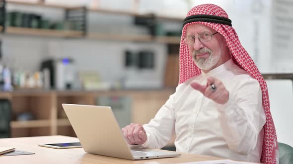Senior Old Arab Businessman with Laptop Pointing at the Camera 