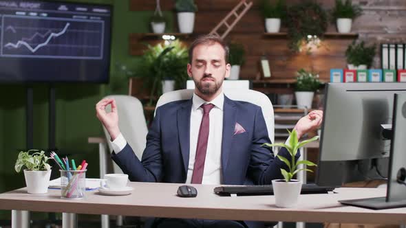 After a Stressful, Long Day, Businessman Meditates Alone in the Office