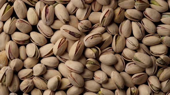 salt pistachios nuts top view rotation. Pistachio nuts in the peel. Whole nut kernels