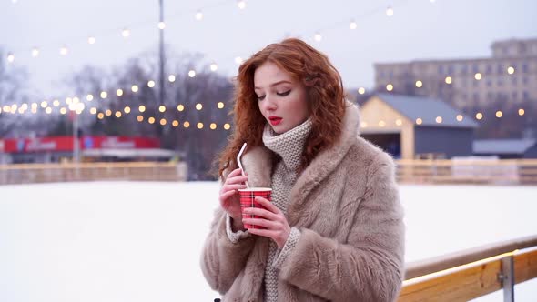 Young Beautiful Redhead Girl Freckles Ice Rink on Background. Pretty Woman Curly Hair Portrait