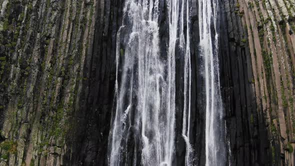 High Waterfall with Fast Water Streams Flows Among Cliffs