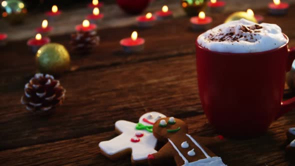 Coffee mug with gingerbread and decoration on a plank
