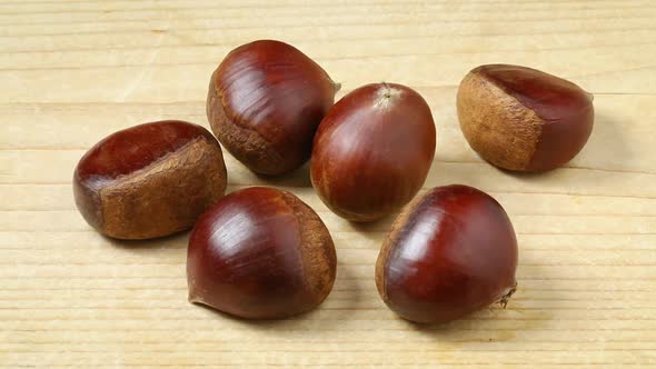 Group of sweet chestnuts on a wooden table close up