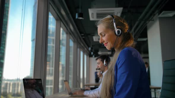 Customer Service Talking To a Customer in Busy Call Center