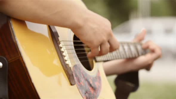 street musician playing the guitar. Only his hands and guitar are visible alt