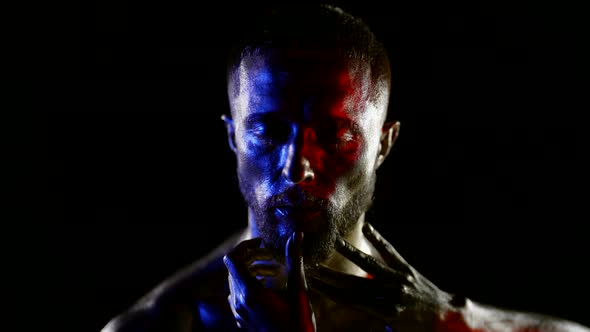 Portrait of a Man with Closed Eyes and Golden Metallic Skin on a Black Background