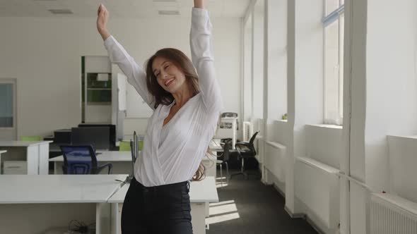 Woman with Long Brown Hair Stands in the Company Room