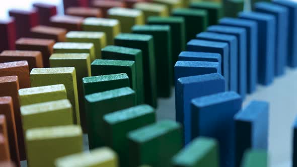 Line up of Dominoes in Rainbow Falling Colors with LGBT Colors of a Hand