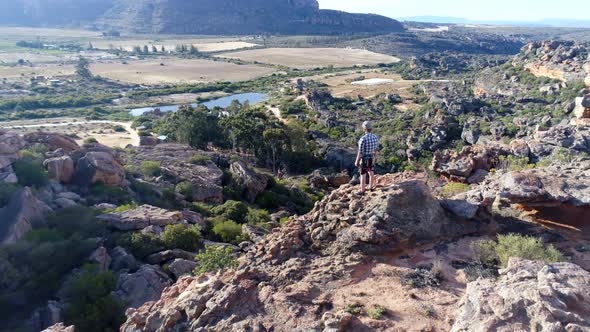 Male rock climber standing over a rocky mountain 4k