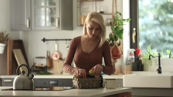 Woman sort apple in basket in kitchen