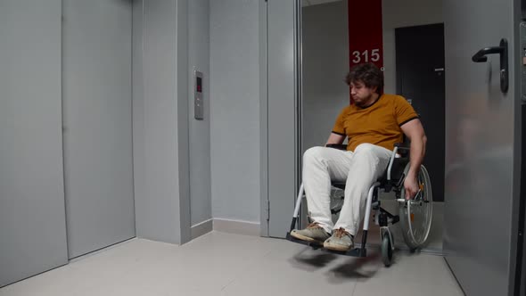 Man in a Wheelchair Rolling to an Elevator and Press the Button