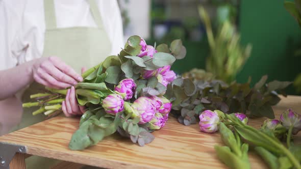 Woman in an Apron Works with Flowers in a Beautiful Store