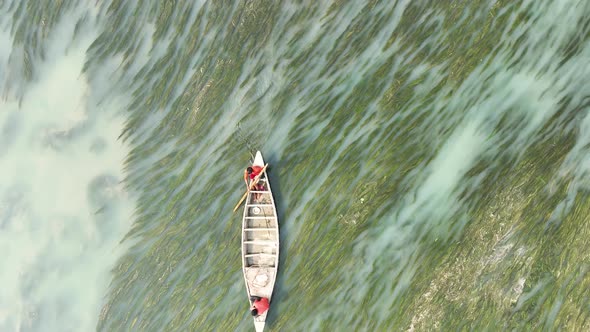 Badalgachhi, Bangladesh - 30 January 2021: Aerial view of fishermen on a canoe sailing the Jamuna