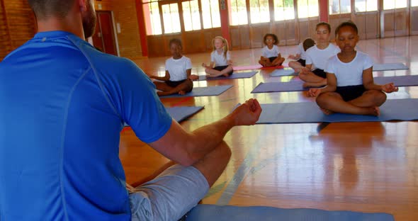 Yoga instructor teaching yoga to school kids in school 4k