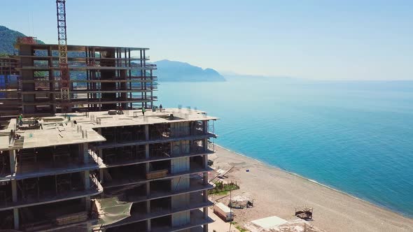 Drone view of construction site multi-storey buildings against background of sea