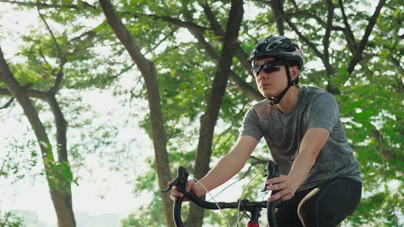 Asian young active male riding bicycle for health in the evening workout sport for his well being.