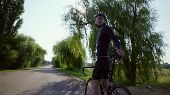 Portrait of Cyclist on the Empty Road Looking on Sides