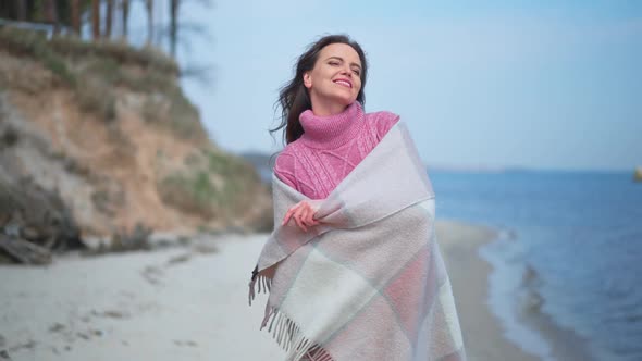 Medium Shot Excited Smiling Woman Spinning with Blanket in Slow Motion at Background of Blue River
