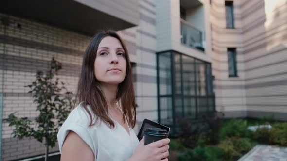 Young Happy Business Woman with Tablet and Drinking Coffee While Walking Slow Motion