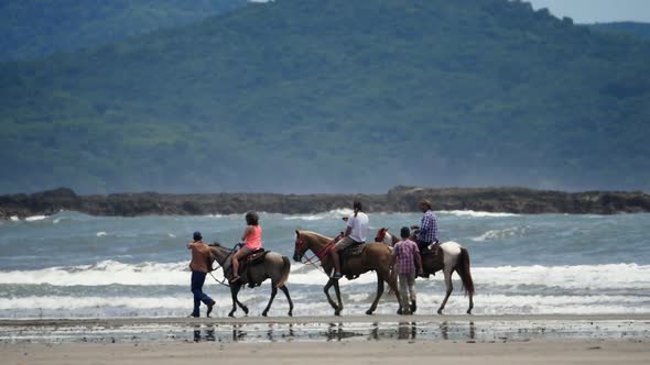 Family Riding Horses on the Seashore