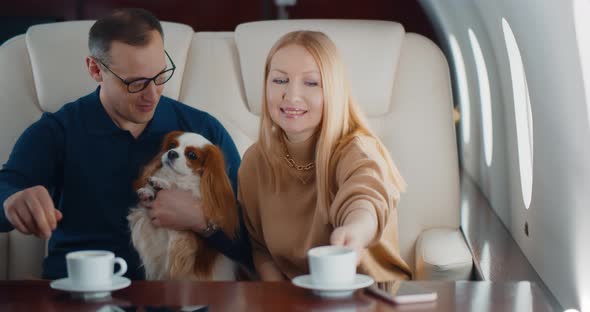 Air Hostess Serving Coffee for Mature Couple in First Class Cabin