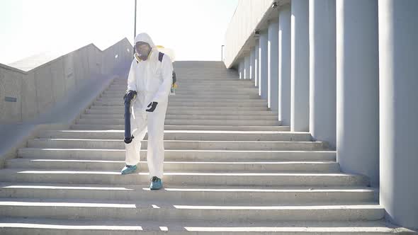 Cleaner with Pressurized Sprayer in Hands Going To Disinfect Public Places