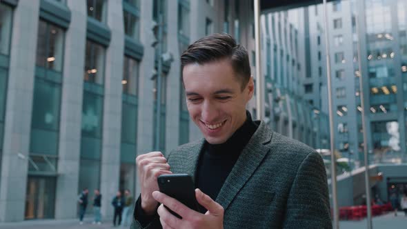 Happy Businessman Winner Looking at Smartphone Feel Overjoyed, Celebrating Mobile Success Bet
