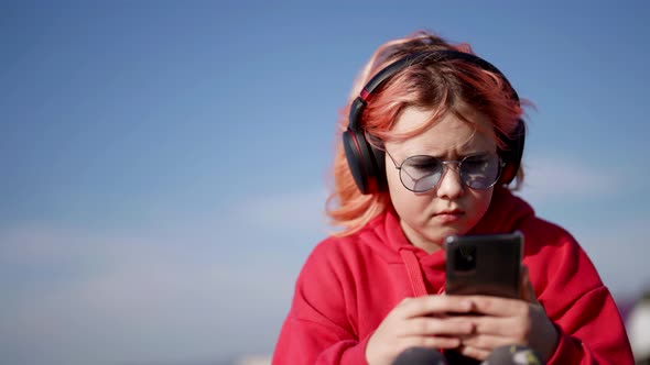 Internet Addiction of Modern Children Little Girl is Playing Video Game in Mobile Phone Outdoors