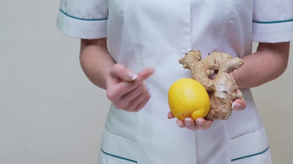 Nutritionist Doctor Healthy Lifestyle Concept - Holding Ginger Root, Lemon and Vitamin Pill