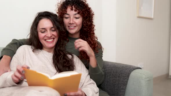 LGBT Hispanic Lesbian Couple Reading a Book Indoor at Home  Gay Love Relationships Concept