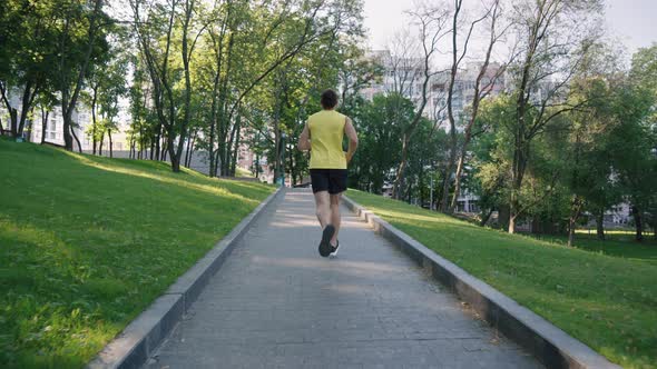 Fit Man Jogging in Park in Slow Motion