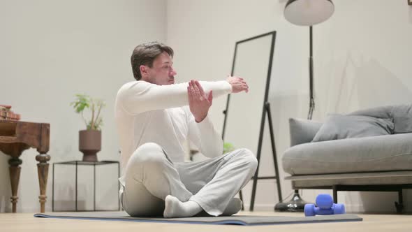 Man Doing Stretches on Yoga Mat at Home