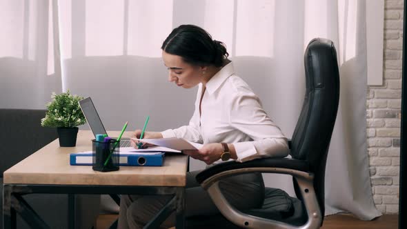 Young Woman Works with Documents in Office