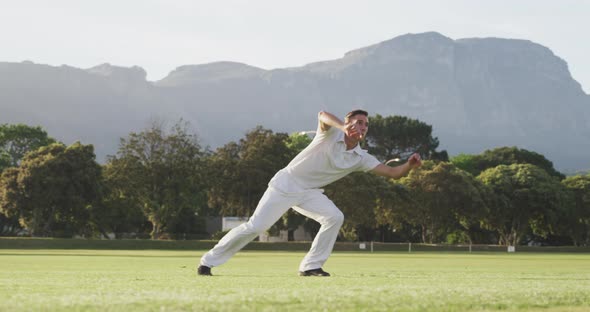 Cricket player catching the ball on the pitch