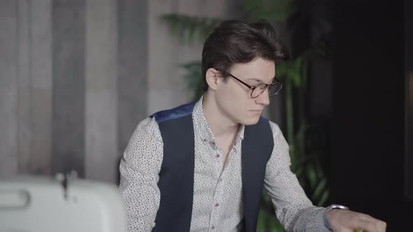 Camera Approaches To Face of Confident Handsome Caucasian Man Examining Textile Samples in Sewing