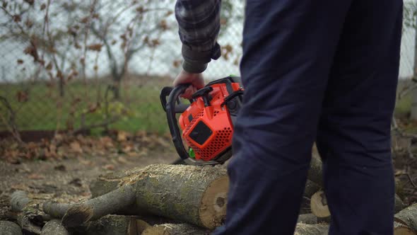 Man Start Chainsaw and Sawing Tree Log Takes Care of Garden and Doing Housework