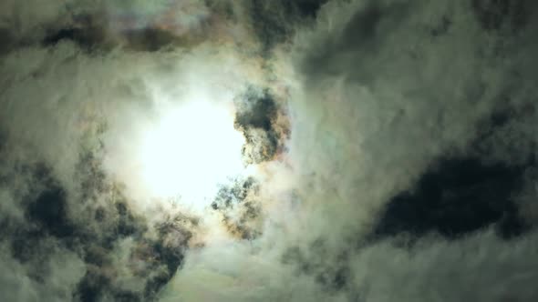 White clouds fly across a sun, dark light