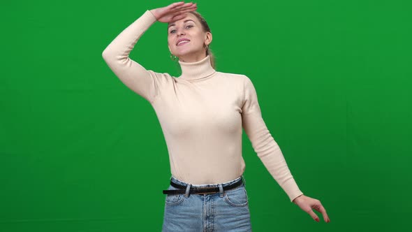 Cheerful Woman Looking Away Smiling Holding Hand at Forehead on Green Screen