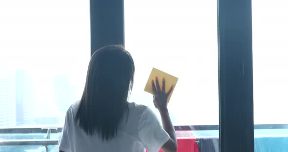 Black woman cleaning window. Home cleaning.