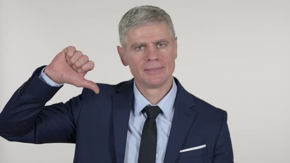 Senior Businessman Gesturing Thumbs Down on White Background