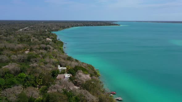 wide aerial coastline of turquoise blue Bacalar Lagoon coastline on sunny day in Mexico
