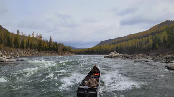 People in a Boat Pass Dangerous Rapids of a Stormy Mountain River Drone Shooting