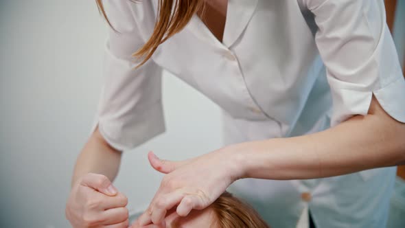 Massage - Woman Massage Therapist Massaging the Face of a Red-haired Young Woman Using Different