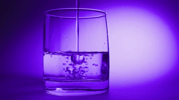 Pouring Fresh Pure Water From Bottle Into a Glass on the Table, Health and Diet Concept