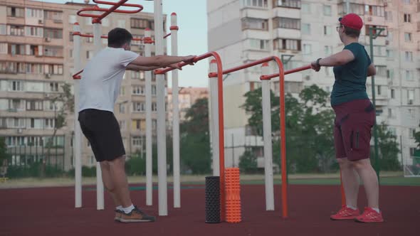 Man and Woman Warming Up and Stretching Before Exercise Outdoor Sports Gym