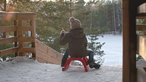 Kid Sliding Downhill on Winter Vacation