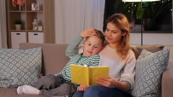 Happy Mother and Son Reading Book Sofa at Home