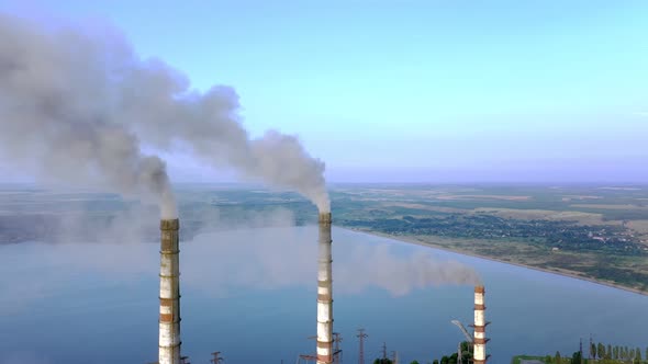 Aerial view of coal power plant high pipes with black smokestack polluting atmosphere